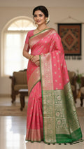Woman wearing a pink saree with green border indoors