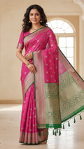 Woman wearing a pink and green saree with a beige wall and window in the background