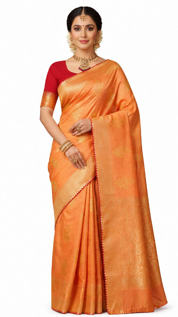 Woman wearing an orange saree with a red blouse on a white background