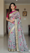 Woman wearing a gray floral sari with a pink blouse in an indoor setting